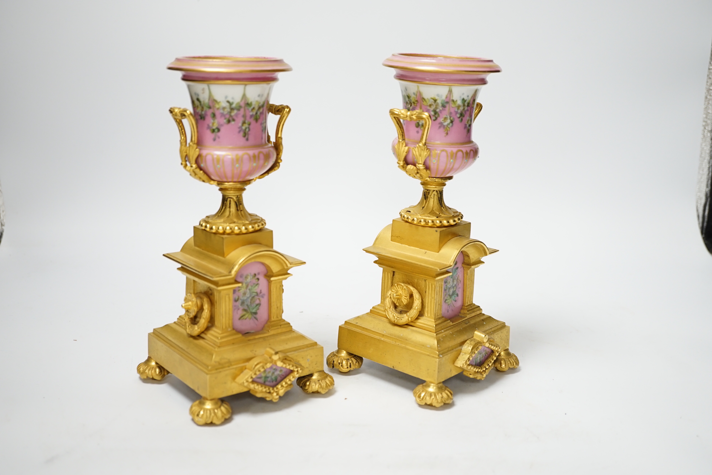 A pair of late 19th century French ormolu and pink floral porcelain urns, 20.5cm high